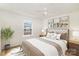 Cozy bedroom with a tufted headboard, neutral bedding, and natural light from the window at 1893 Hilltop Cir, Gastonia, NC 28054