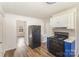 Kitchen featuring black appliances, new floors, and an adjacent living space at 1893 Hilltop Cir, Gastonia, NC 28054