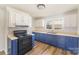 Well-lit kitchen with blue cabinets, stainless steel sink, and modern appliances at 1893 Hilltop Cir, Gastonia, NC 28054