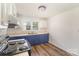 Charming kitchen featuring blue cabinets, white upper cabinets, and vinyl flooring at 1893 Hilltop Cir, Gastonia, NC 28054