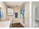 The bathroom features built-in storage, a floral shower curtain, and neutral walls at 1911 Woodlawn St, Kannapolis, NC 28083