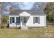 Charming one-story home featuring a brick chimney, symmetrical black shutters, and manicured landscaping at 1911 Woodlawn St, Kannapolis, NC 28083