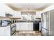 Bright kitchen with white cabinets, stainless steel appliances, and a charming window view at 1911 Woodlawn St, Kannapolis, NC 28083