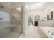 Bright bathroom with a walk-in glass shower, skylight, and neutral tile at 20338 Christofle Dr, Cornelius, NC 28031