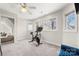 Sunlit bedroom with exercise bike, carpet, and natural lighting through windows at 20338 Christofle Dr, Cornelius, NC 28031