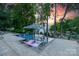 An inviting pool with lounge chairs and clear water is surrounded by beautiful landscaping and mature trees at sunset at 20338 Christofle Dr, Cornelius, NC 28031