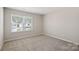 Neutral carpeted bedroom is flooded with natural light from a large window at 2124 Clapham Ct, Charlotte, NC 28215