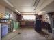 Large basement with workbench, storage, and industrial style lighting at 257 Hickory Hill Ln, Stanley, NC 28164