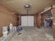 Spacious garage with white door, overhead lighting, and storage shelves at 257 Hickory Hill Ln, Stanley, NC 28164