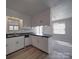 Kitchen showcasing white cabinetry, laminate flooring and stainless steel dishwasher at 257 Hickory Hill Ln, Stanley, NC 28164