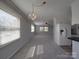 Open-concept living space connecting kitchen with carpet and natural light from large windows at 257 Hickory Hill Ln, Stanley, NC 28164