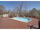 Backyard pool and deck area with a lounge chair and outdoor fireplace at 257 Hickory Hill Ln, Stanley, NC 28164