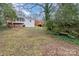 Exterior view of a lush backyard featuring mature trees and surrounding greenery at 3504 Meredith Ave, Charlotte, NC 28208