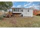 Exterior view of backyard with white brick home and deck with staircase at 3504 Meredith Ave, Charlotte, NC 28208