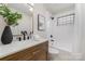 Updated bathroom with wood vanity, modern fixtures, and tiled shower and featuring natural decor at 3504 Meredith Ave, Charlotte, NC 28208