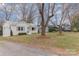 Attractive one-story white brick home with mature trees shading the front yard, with green shutters at 3504 Meredith Ave, Charlotte, NC 28208