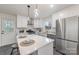 Bright and modern kitchen with white cabinets, stainless steel appliances, and an island with bar seating at 3504 Meredith Ave, Charlotte, NC 28208