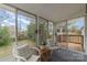 Relaxing sunroom featuring wicker furniture and scenic views of the backyard and beautiful natural light at 3504 Meredith Ave, Charlotte, NC 28208