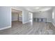 Bright living room with gray walls and modern gray wood-look floors, open to other rooms at 4211 Little Mountain Rd, Gastonia, NC 28056