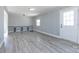 Bright living room with gray walls and modern gray wood-look floors, with exterior door and small window at 4211 Little Mountain Rd, Gastonia, NC 28056