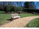 Serene backyard bench on a gravel path surrounded by lush greenery and mature trees at 425 Gladelynn Way, Waxhaw, NC 28173