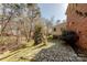 Stone path leading through backyard with mature trees and well-maintained lawn at 4840 Autumn Leaf Ln, Charlotte, NC 28277