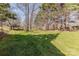 Large, grassy backyard with mature trees providing shade and a sense of privacy at 4840 Autumn Leaf Ln, Charlotte, NC 28277