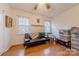 Bedroom with wood floors, two bright windows, and a convertible sofa at 4840 Autumn Leaf Ln, Charlotte, NC 28277