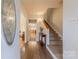 Inviting foyer with hardwood floors, staircase, and decorative glass front door at 4840 Autumn Leaf Ln, Charlotte, NC 28277