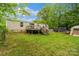 Image of the home's backyard with wooden deck, green lawn, and a few storage buildings at 5128 Green Leaf Ct, Mount Holly, NC 28120