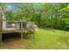 Wide backyard view of outdoor wooden deck with railing and stairs to the well-maintained lawn at 5128 Green Leaf Ct, Mount Holly, NC 28120