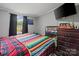 Inviting bedroom with window and dresser and mounted TV at 5128 Green Leaf Ct, Mount Holly, NC 28120