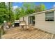View of outdoor wooden deck with BBQ grill, table and chair, and sliding glass door into the home at 5128 Green Leaf Ct, Mount Holly, NC 28120