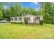 Exterior view of home with manicured front lawn and small front porch at 5128 Green Leaf Ct, Mount Holly, NC 28120
