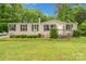 Charming home featuring a well-maintained lawn, mature trees, and inviting front porch at 5128 Green Leaf Ct, Mount Holly, NC 28120