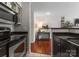 Galley kitchen with stainless steel appliances, black countertops, and tile flooring at 529 N Graham St # 2G, Charlotte, NC 28202