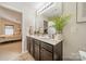 Bright bathroom featuring double sinks with a vanity, soft lighting and a view into an adjacent bedroom at 5306 Graypark Dr, Charlotte, NC 28269