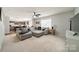 Bright living room with a ceiling fan, large windows, and a comfortable gray couch with a view to the kitchen at 5306 Graypark Dr, Charlotte, NC 28269