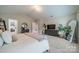 Bright main bedroom featuring neutral walls, a decorative dresser, and a doorway to an organized closet at 5306 Graypark Dr, Charlotte, NC 28269