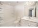 Bright bathroom has a shower/tub combo, single sink vanity, and tile flooring at 5532 Axil Ln, Charlotte, NC 28269