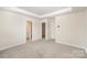 Spacious bedroom with carpet, a tray ceiling, and two doorways at 5532 Axil Ln, Charlotte, NC 28269