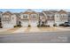 Street view of craftsman-style townhomes, each with a single-car garage and manicured lawns at 5532 Axil Ln, Charlotte, NC 28269