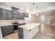 Lovely kitchen with stainless steel appliances, gray cabinets, backsplash, and a center island with countertop at 5532 Axil Ln, Charlotte, NC 28269