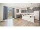 Modern kitchen with gray cabinets, quartz countertops, stainless steel appliances, and a sliding glass door at 5532 Axil Ln, Charlotte, NC 28269