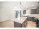 Open-concept kitchen with gray cabinets, backsplash, stainless steel appliances, and center island with countertop at 5532 Axil Ln, Charlotte, NC 28269