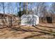 Backyard shed with a ladder shows ample storage space, set against a backdrop of mature trees and fencing at 6215 Coatbridge Ln, Charlotte, NC 28212