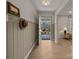 Inviting foyer featuring light wood floors, a decorative hat rack, and a view to the front door at 6215 Coatbridge Ln, Charlotte, NC 28212