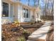 This exterior shows a white brick home with a front porch and a landscaped yard at 6215 Coatbridge Ln, Charlotte, NC 28212