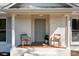 Close-up of the front porch with neutral paint, chairs and a welcome mat at 6215 Coatbridge Ln, Charlotte, NC 28212