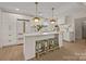 Bright kitchen with island, white cabinets, pendant lighting, and stainless appliances at 6215 Coatbridge Ln, Charlotte, NC 28212